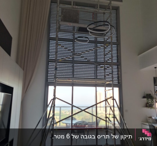 תריסים מוגפים עם פיגום בחזית חלון גדול